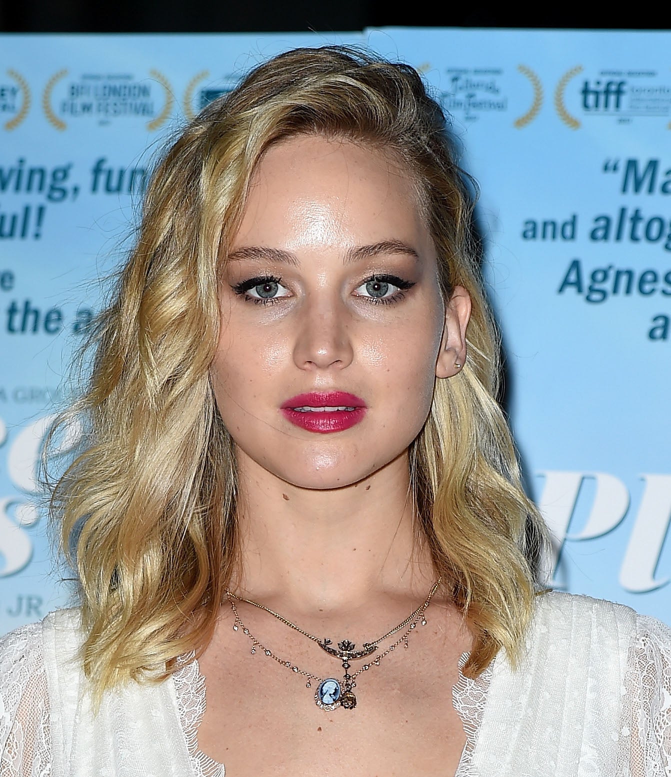 Jennifer Lawrence con un maquillaje muy luminoso, con sombras marrones, eyeliner negro y labios en rosa fresa.