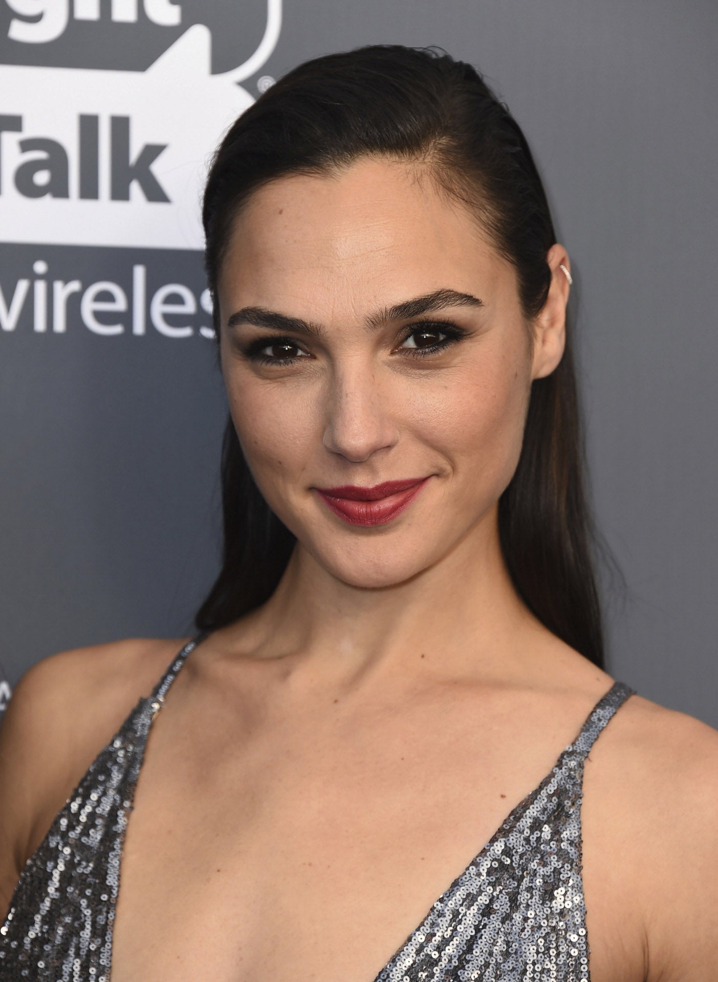 Gal Gadot con un 'wet look' con melena suelta y labios rojos.