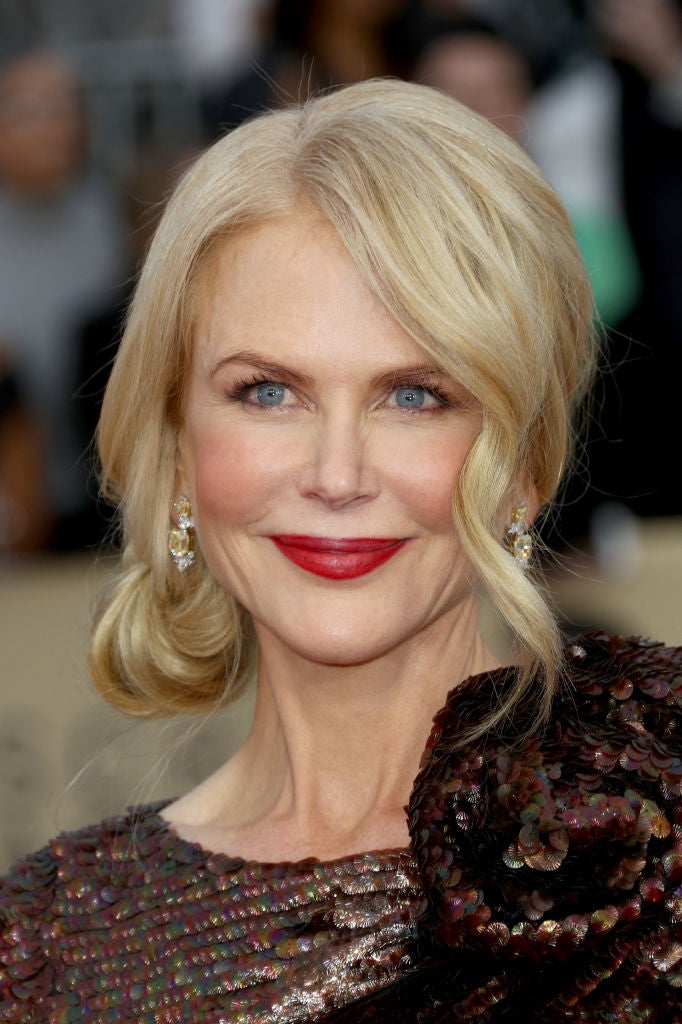 Nicole Kidman con un recogido lateral con mechones sueltos y labios rojos.