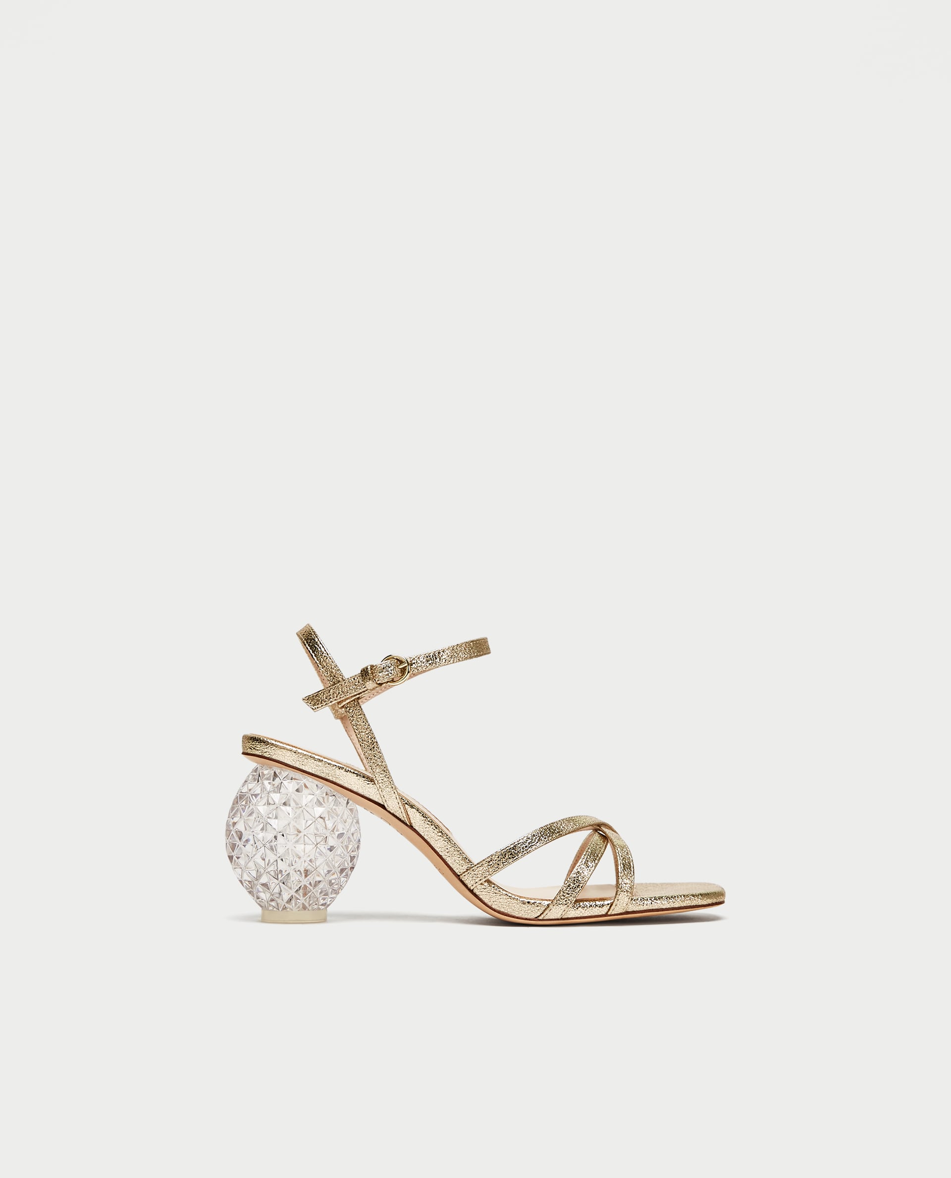 Sandalias doradas con tacón esférico de Zara. Precio: 59,95 euros.