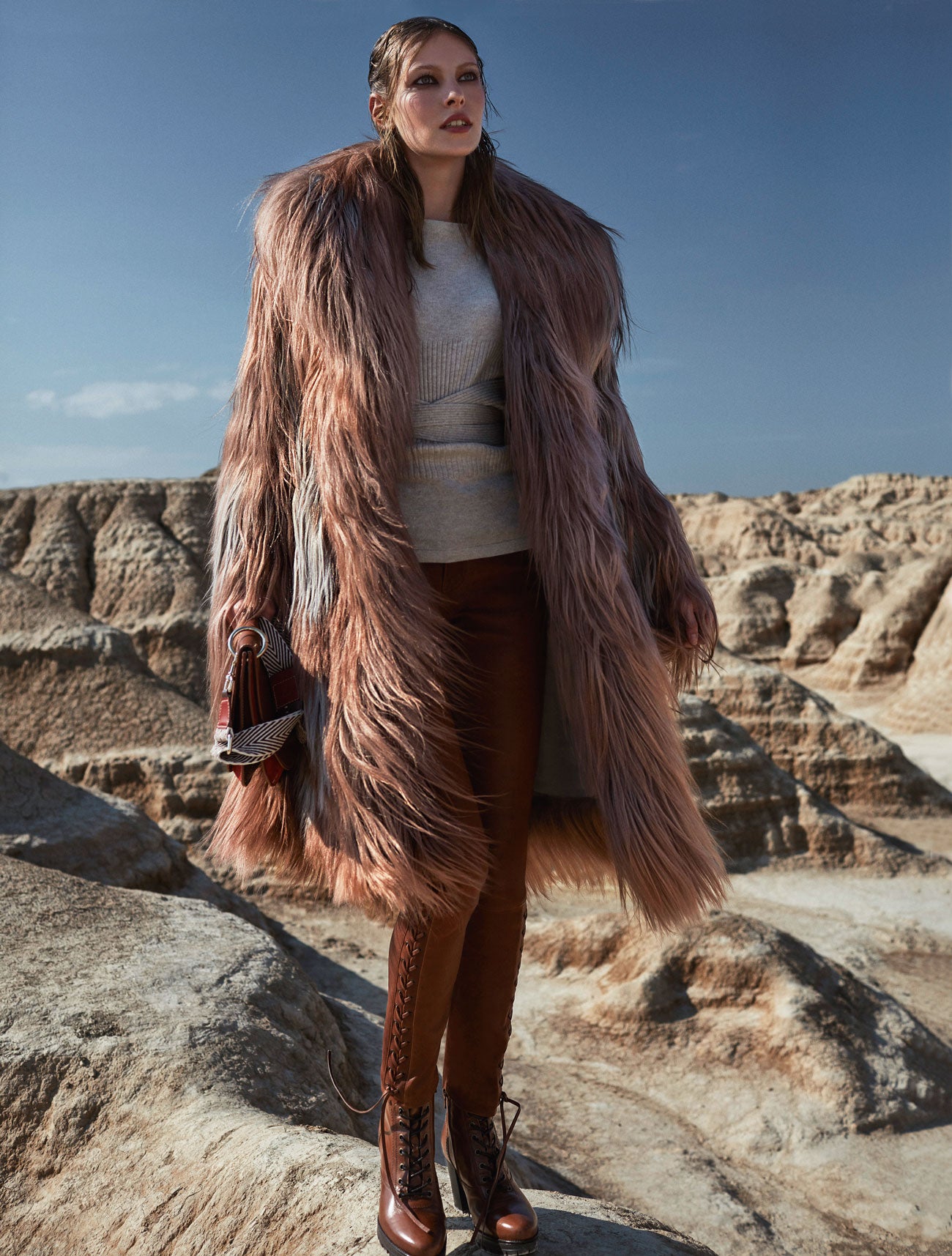 Bajo un abrigo de Bottega Veneta, jersey de Pedro del Hierro y pantalón de cuero, de Polo Ralph Lauren. Botas de Nero Giardini y bolso de CH Carolina Herrera.