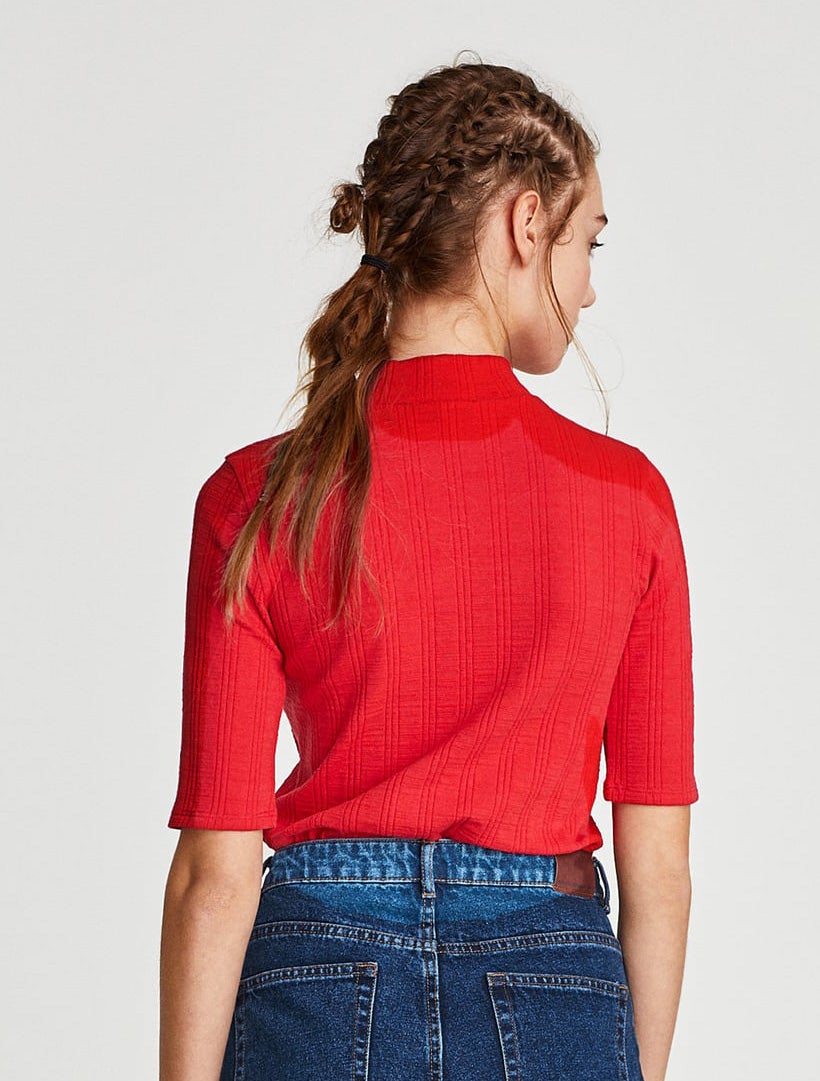 Mini trenzas tribales que acaban en una coleta baja.