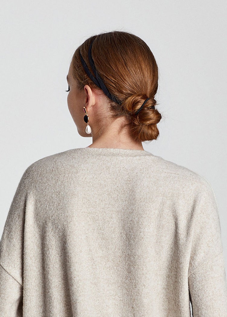 Recogido bajo enrollado con goma y adornado con una diadema de cinta.