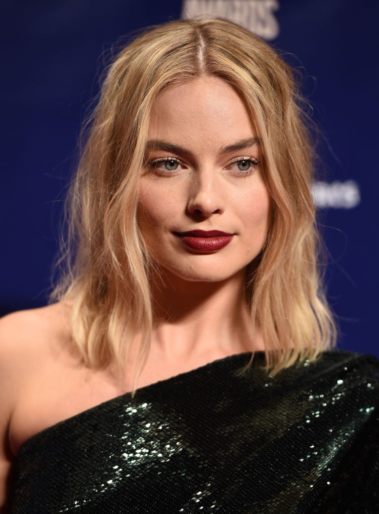 Margot Robbie con su media melena peinada con raya en el medio y ondas surferas.