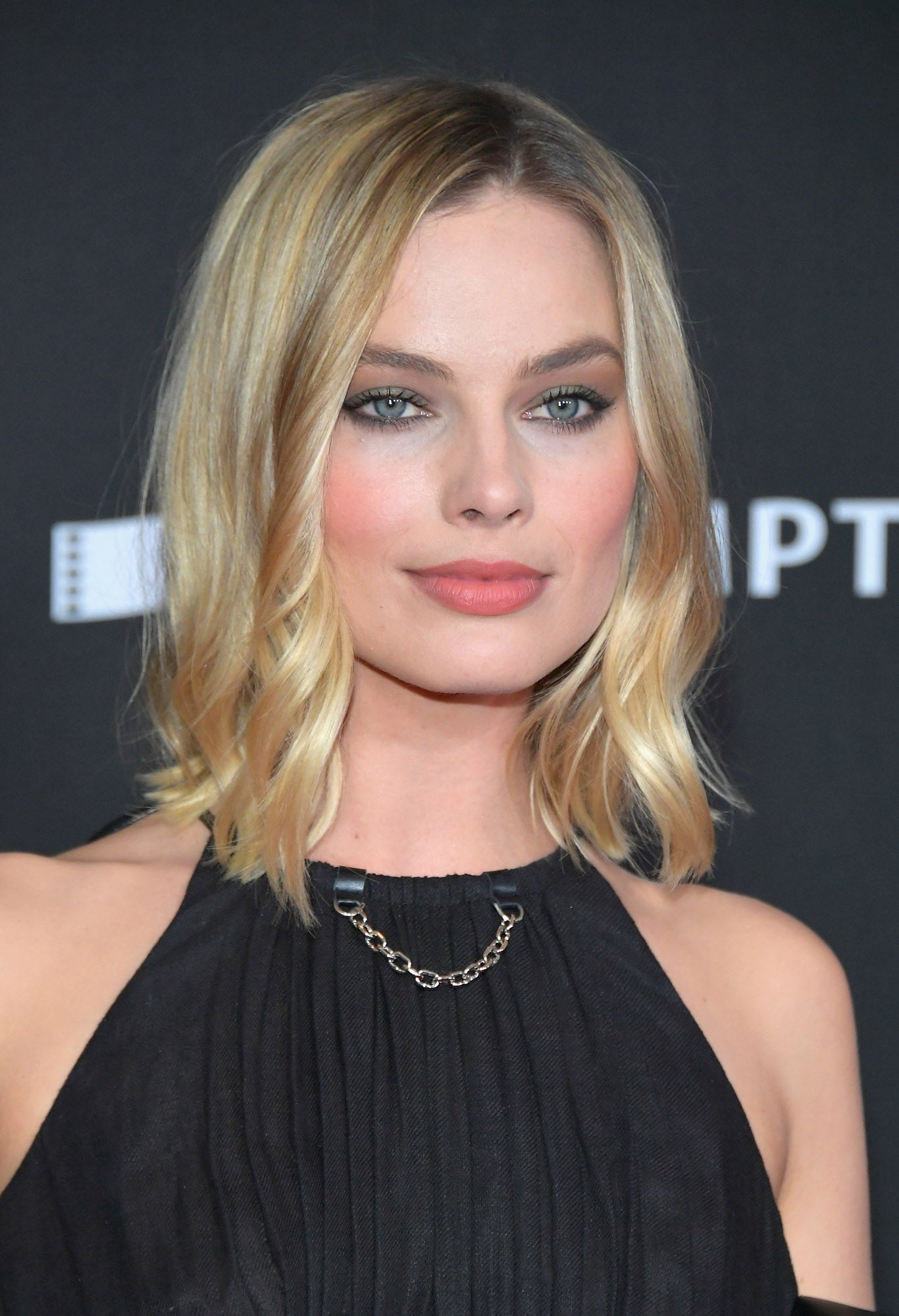 Margot Robbie con media melena lisa, con las puntas vueltas, y ondas en los mechones que enmarcan el rostro.