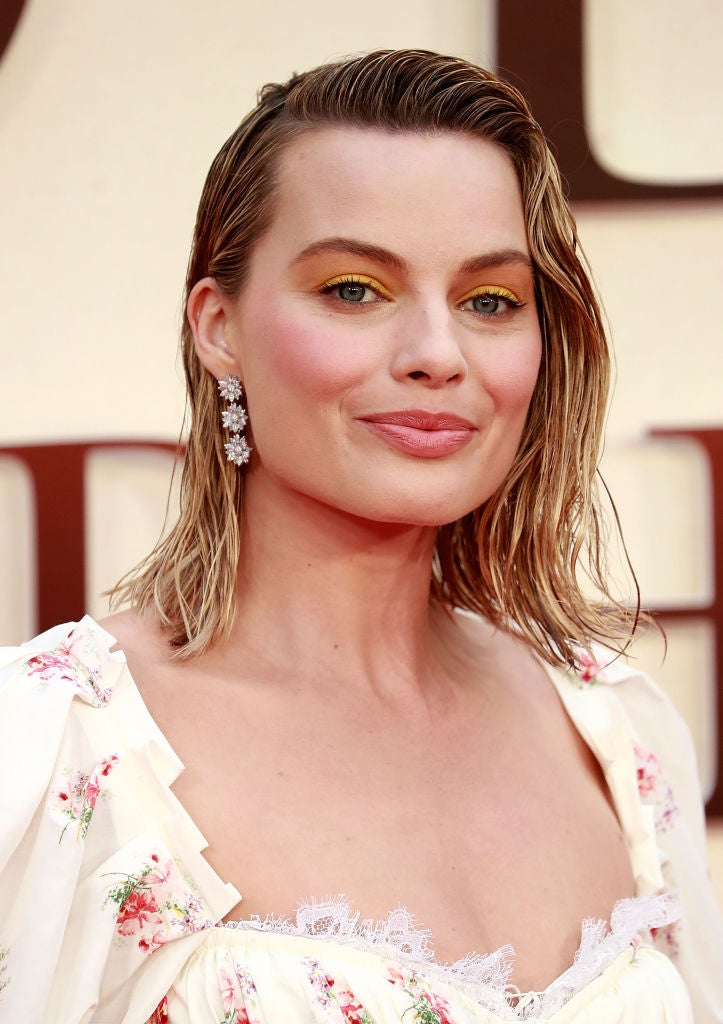 Margot Robbie con su media melena peinada con efecto 'wet' o mojado, con raya hacia un lado y mini tupé.