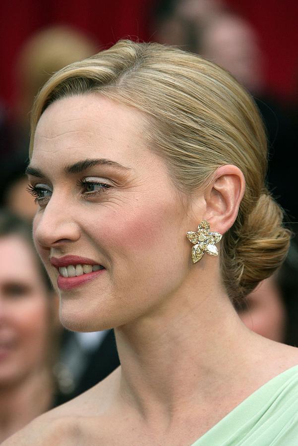 Kate Winslet en los Oscar 2007 con moño bajo y raya lateral y un maquilla en tonos suaves con labios rosas.
