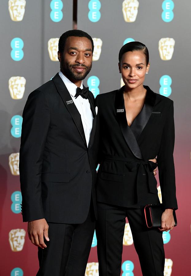 Chiwetel Ejiofor y Frances Aaternir, ambos con traje negro.