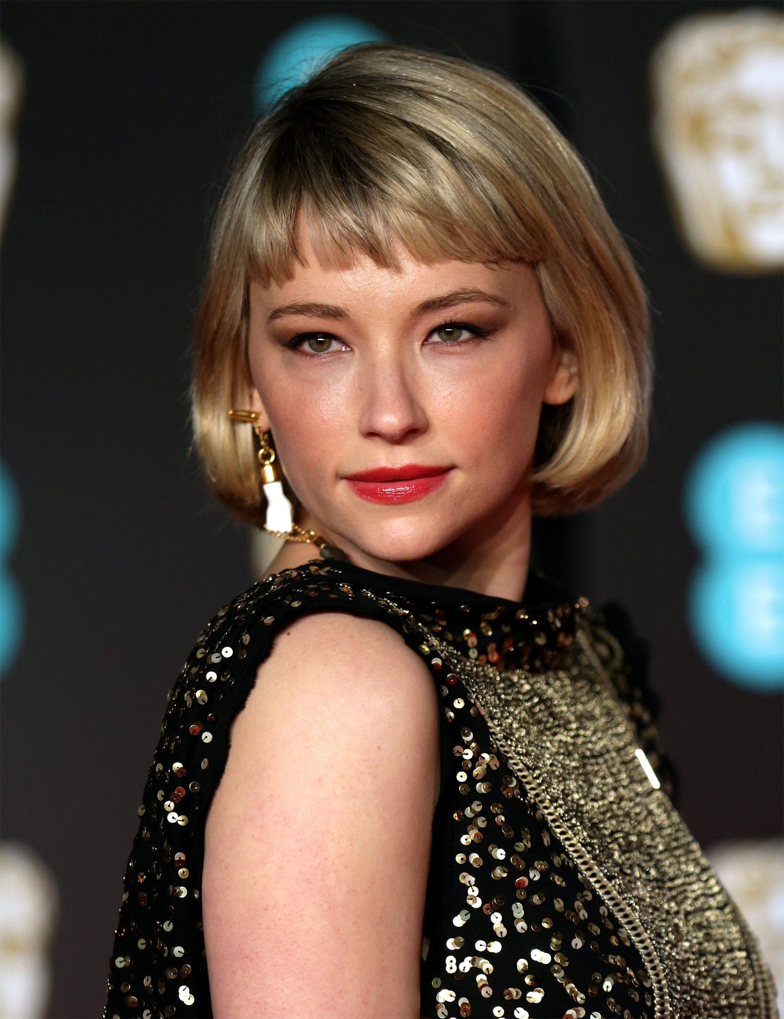 Haley Bennett con bob y flequillo baby bangs y un bonito maquillaje con sombras marrones y labios rojos con acabado charol.