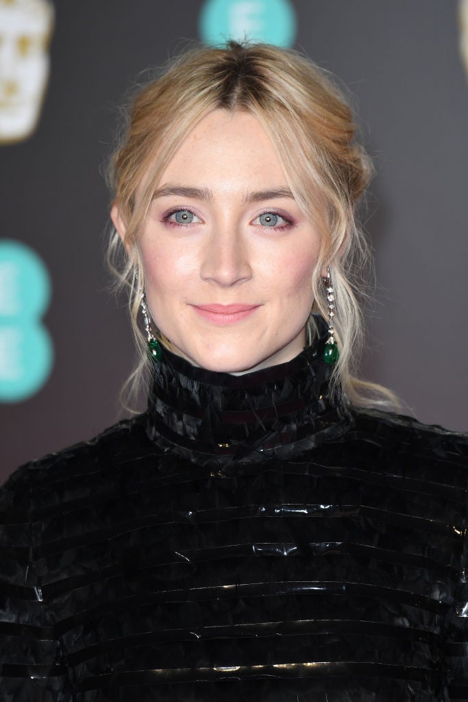 Saoirse Ronan con un recogido de corte romántico con mechones sueltos y maquillaje en tonos rosas.