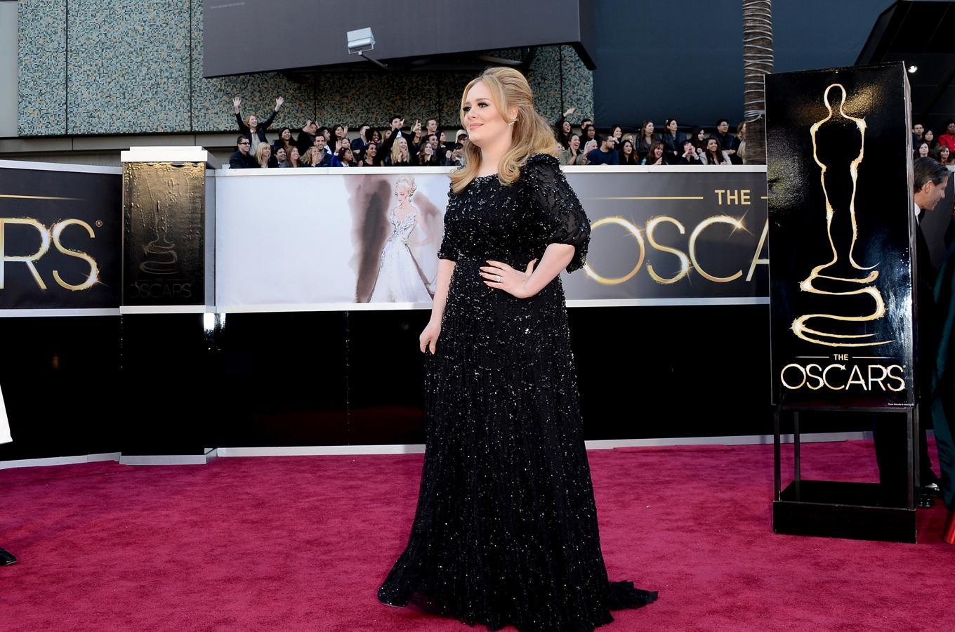En 2013, Adele lució un vestido negro de pedrería de Jenny Packham, muy similar al que escogió para subirse al escenario, que era corto y de Burberry