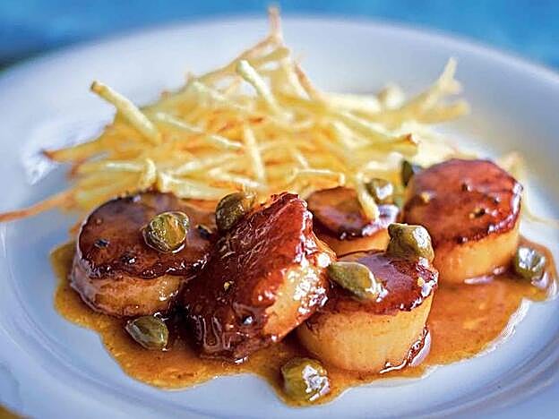 Este es el aspecto de las vieiras con mantequilla negra y patatas paja.