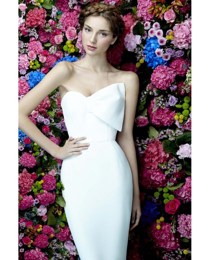 Vestido blanco de estilo tubular con escote palabra de honor con lazo de Dolores Promesas. Precio: 190 euros.