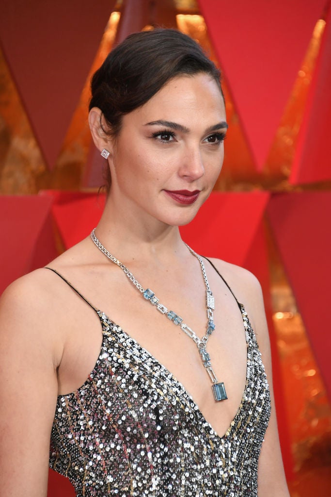 Gal Gadot lució un moño italiano con raya lateral y onda y un maquillaje clásico con eyeliner negro, máscara de pestañas y labios rojos.