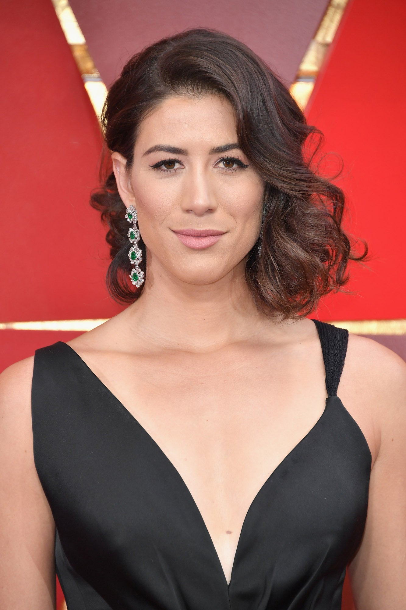 La tenista Garbiñe Muguruza con su media melena ondulada y semirrecogida en un lado y un bonito maquillaje con eyeliner negro y labios rosas.