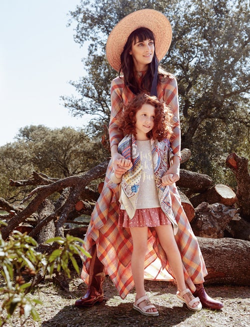 La modelo lleva vestido de cuadros, de Hermès; sombrero de Mimoki; y botas de agua, de Igor. La niña, pañuelo de Hermès, vestido de Brotes, jersey de Nicoli y sandalias de Primigi.