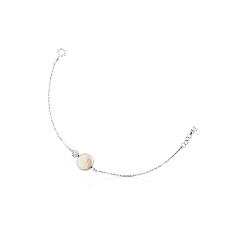 Con una pulsera en oro blanco de Tous de 18kt, perla y diamantes