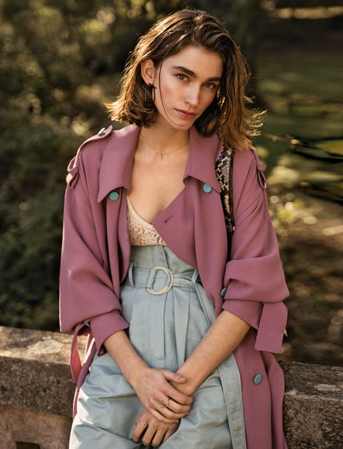 Gabardina morada con botones azules de Edeline Lee. Debajo, body de encaje, de Nina Ricci y pantalón de Mango.Sortijas y collar de Gemmasu.Pendientes geométricos y bolso con asa de pitón, de Salvatore Ferragamo. El cabello se ha tratado con Brume D'Huile de Kérastase.