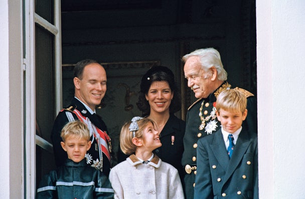 Entre sus hermanos, mirando con complicidad al príncipe Rainiero, ante su madre y su tío Alberto.