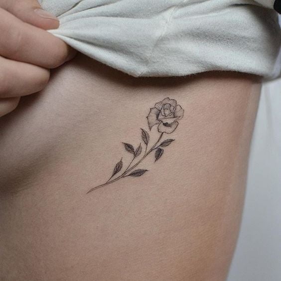Flor tatuada en el costado, justo al lado del pecho.
