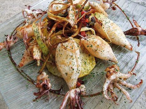 Chipirones sobre patatas panaderas con puerro y cebolla.