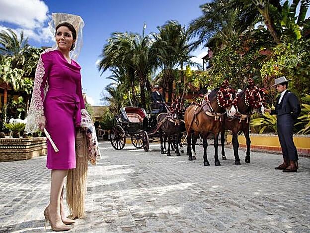 Paloma Segrelles junto a un coche de caballos.