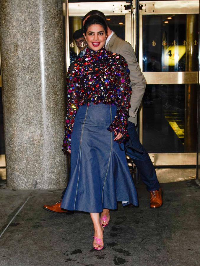 Priyanka Chopra estaba impresionante con un conjunto de falda de quillas azul marino de largo midi y top de paillettes con mangas acampanadas de Carolina Herrera. Los mules rosas, estilo Cenicienta, eran de Gianvito Rossi.