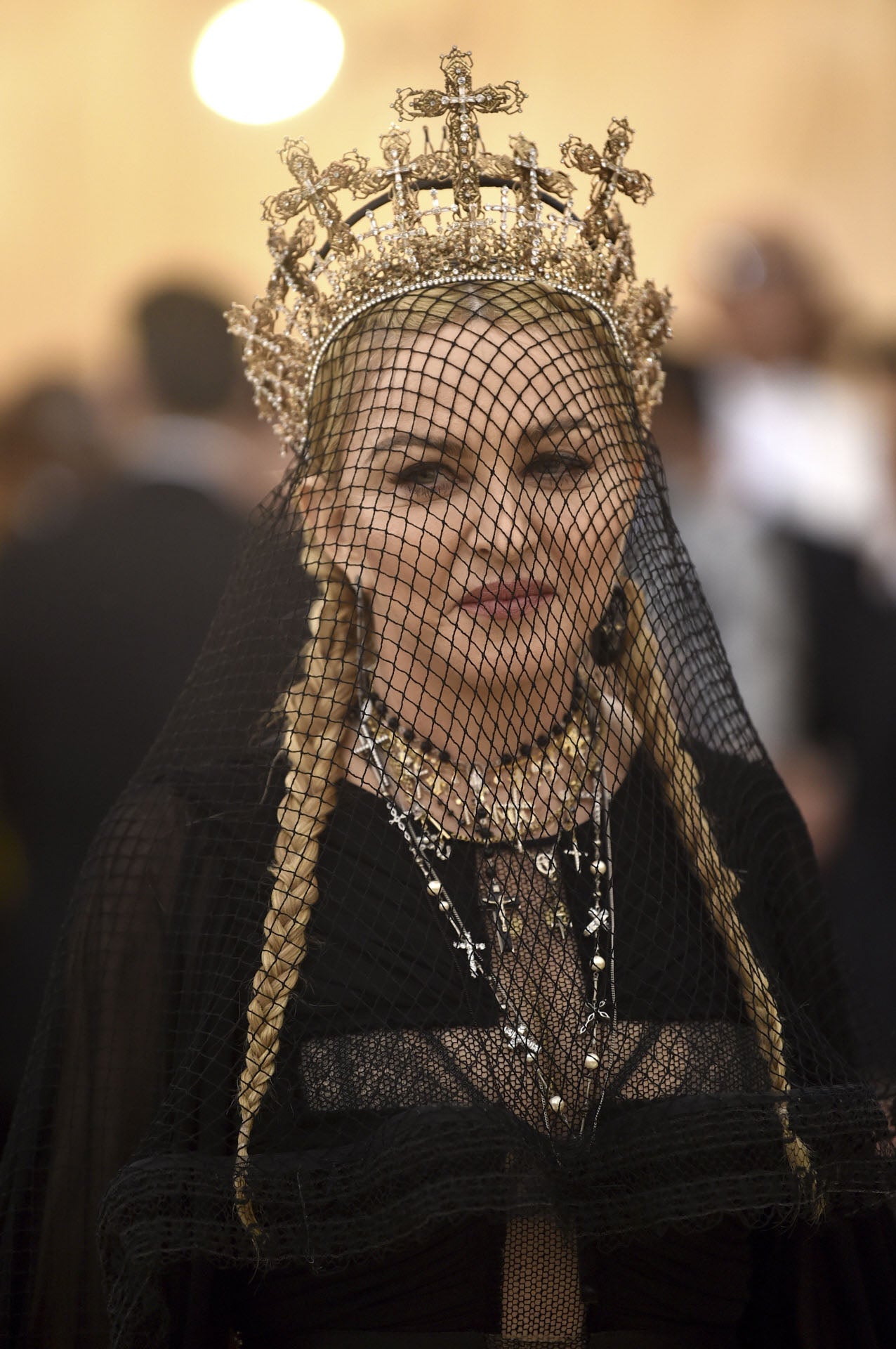 Madonna tampoco podía defraudarnos. La cantante, que ya ha lucido signos católicos en numerosas ocasiones, se ha decantado por un velo de rejilla negro, adornado con una corona dorada con cruces. Debajo Madonna ha recogido su melena en dos trenzas indias.