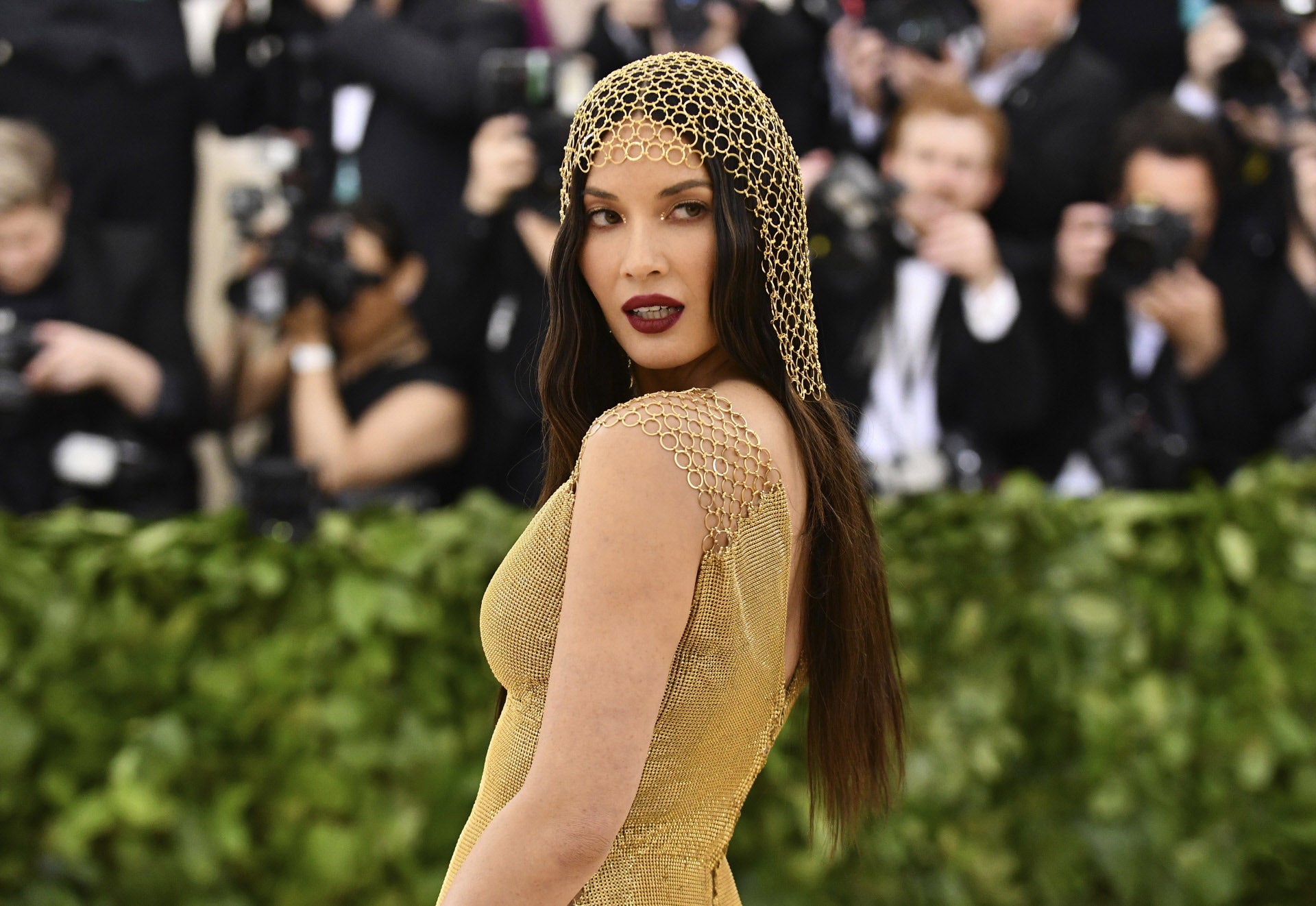 Olivia Munn con uno de los tocados más discretos, una mastilla dorada a juego con el vestido. La actriz ha lucido melena maxi gracias a las extensiones.