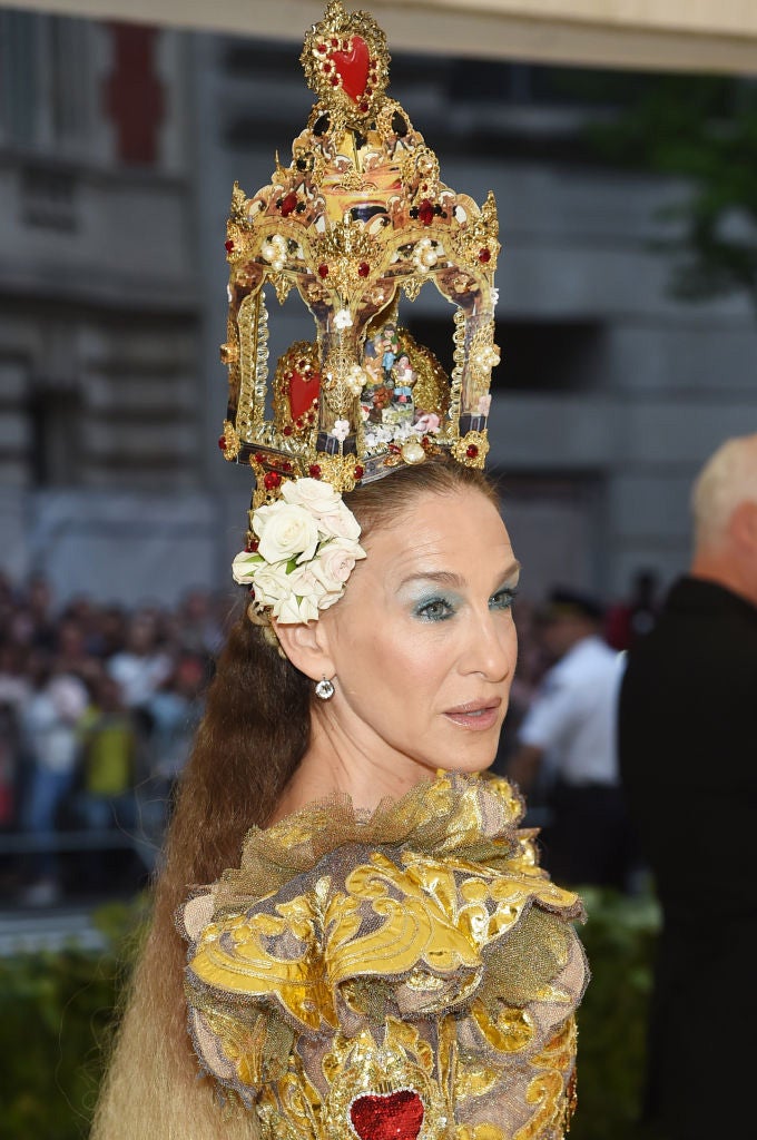 Sarah Jessica Parker es una de las famosas que más arriesga en la Gala Met. Su tocado es de los más excéntricos: se trata de un retablo en el que se representa un nacimiento (o eso creemos). Su melena entre encrespada y pelo frito nos ha dejado sin palabras.