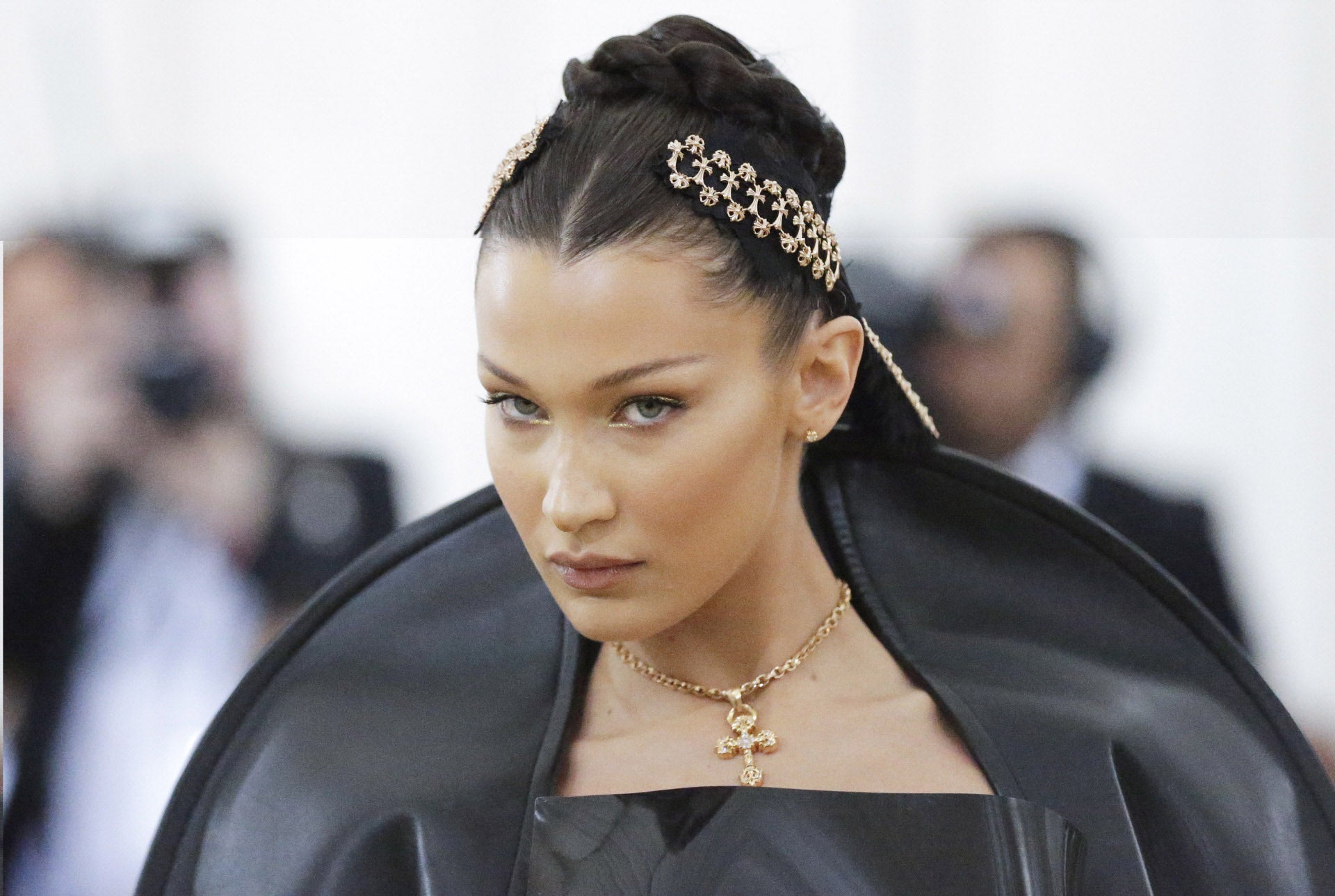 Bella Hadid ha lucido un moño alto trenzado (será un postizo o extensiones, ya que la modelo ahora mismo luce un long bob) que ha adornado con unas curiosas cintas negras y doradas.
