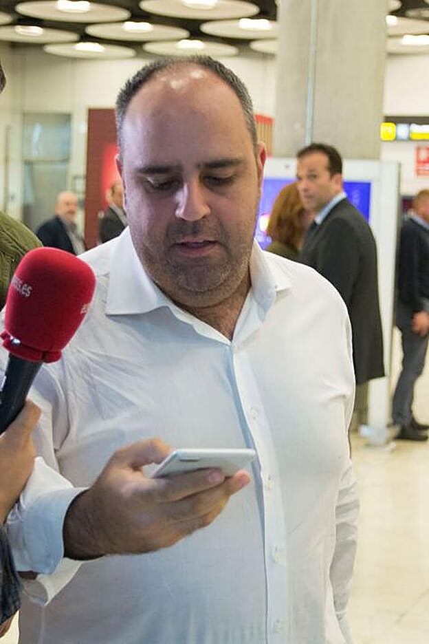 Julio Ruz mira su móvil a su llegada al aeropuerto de Barajas desde Honduras.