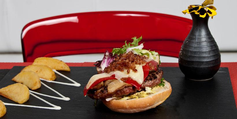 La propuesta de Sushi&Buey (del Grupo El Txoko) pasa por la fusión de una carta bien equilibrada en la que podemos elegir entre la comida japonesa más tradicional y una reinvención de la típica hamburguesa americana con ingredientes 'typical spanish' como los pimientos del piquillo o el queso Idiazábal (la Okela, en la foto). El toque secreto de su 'salsa Sushi&Buey' (una mayonesa japonesa deliciosa) pone la guinda a platos contundentes y exquisitos que se coronan con patatas gajo y un pan de mollete. Sushi&Buey está en la Avenida de Logroño, 112; y en la Avenida del Príncipe Carlos, 22.