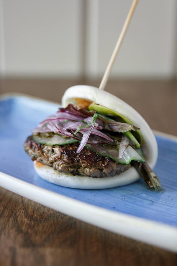 Si quieres sorprender, y dejarte sorprender los sentidos en el Día de la Hamburguesa, prueba el Bao de Hamburguesa de atún de Latasia (Paseo de la Castellana, 115). Lo elaboran macerando el atún con cebollino mostaza y salsa de soja y lo sirven en un suave bao acompañado de brotes de lechuga, pepino y hojas de mostaza encurtidas, acompañado de mahonesa de kimchi y criolla.