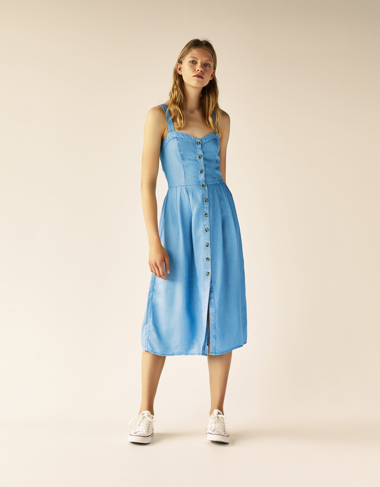 En tejido dénim, con escote corazón y botones de madera, de Bershka (29.95 euros).