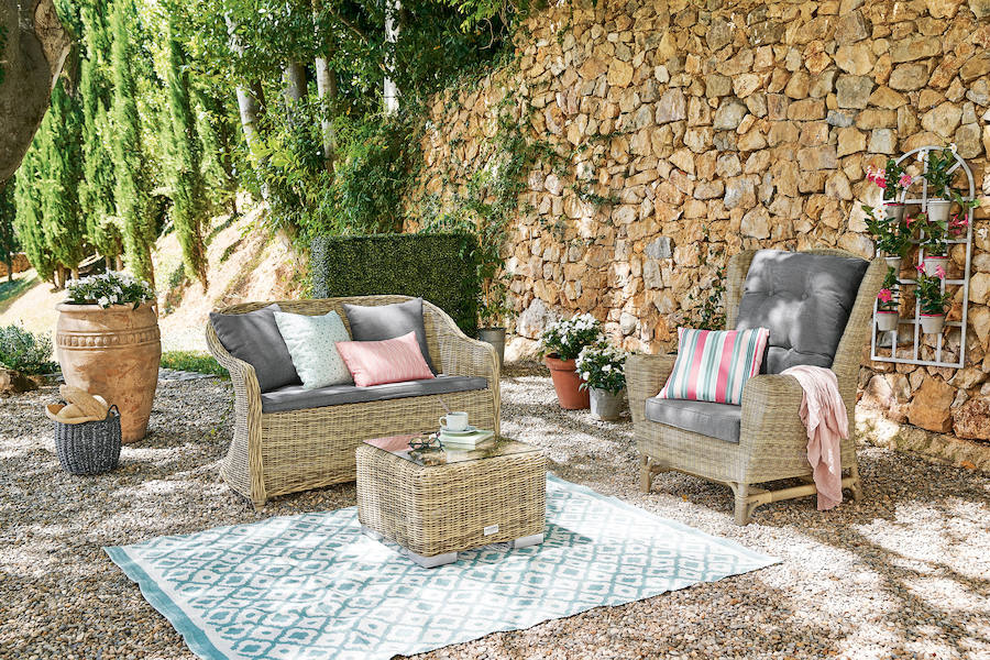 De nuevo el ratán y los tejidos naturales adornados con pinceladas de color 'soft' marcan la diferencia en espacios exteriores tan apetecibles como este rincón en el jardín.