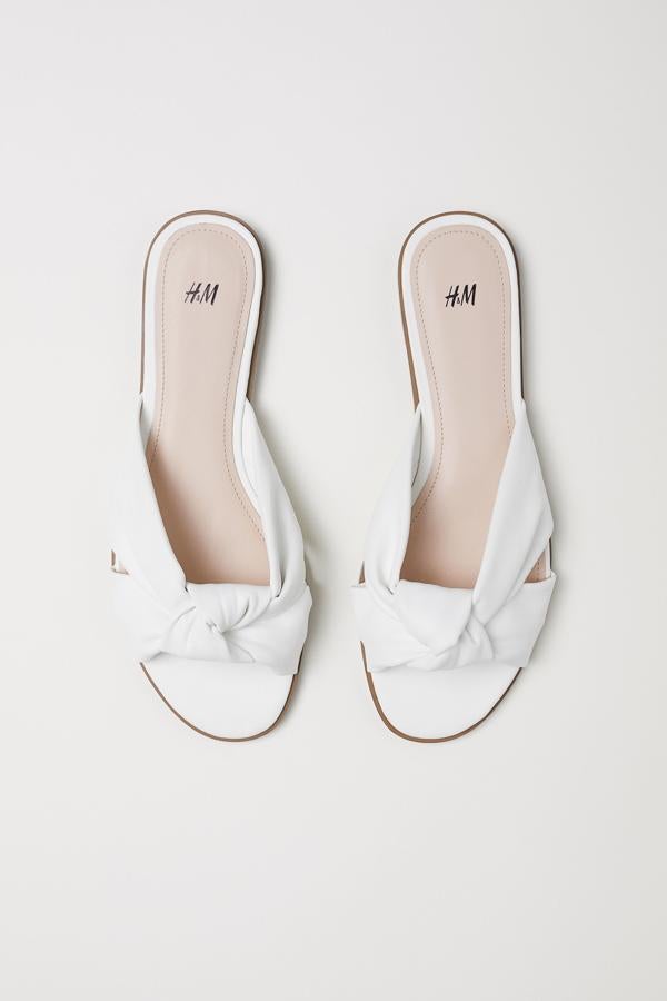 Unas sandalias blancas deberían ser obligatorias en tu maleta de vacaciones. Con la piel morena, te harán unas piernas envidiables.