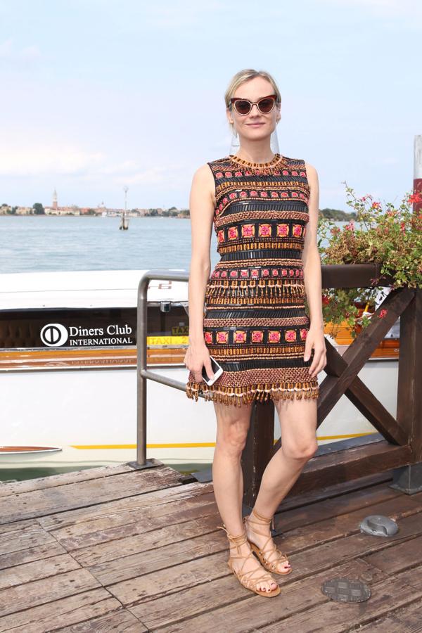 Diane Kruger todo un referente de estilo con este mini vestido con toques étnicos, saldalias planas con cordones en color marrón y unas gafas 'cat eye'.