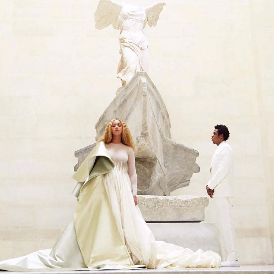 La Victoria del amor. Los Carter, vestidos de impecable blanco, rodean la icónica Victoria de Samotracia, un auténtico tesoro de la humanidad, datada alrededor del siglo II antes de Cristo. El espectacular vestido arquitectónicamente esculpido de Beyoncé, una creación de Alexis Mabille, remite a los pliegues de mármol de la toga de la Victoria, de forma que no sabemos ante quién se rinde el cuerpo de baile, si ante el poder y la influencia de la diosa que ganaba todas las batallas o ante su equivalente de carne y hueso.