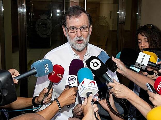 Mariano Rajoy atiende a los medios antes de incorporarse a su puesto de trabajo de registrador de la propiedad.