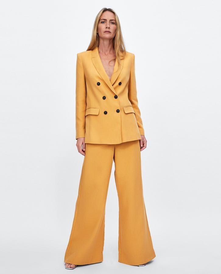 Este traje amarillo de inspiración setentera ha sido una de las sensaciones de la temporada que estamos seguras llegará a muy buen precio en rebajas. Antes de los descuentos, la chaqueta cuesta 69.95 euros y los pantalones, 39.95 euros.