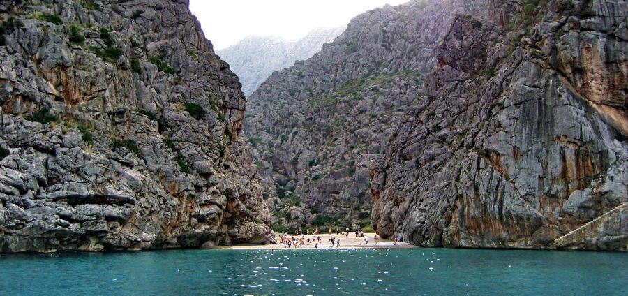 A la Cala de Sa Calobra en Torrent de Pareis (Mallorca) solo se puede acceder a través de una ruta de senderismo. El recorrido es espectacular y la sorpresa llega al final del camino, cuando encuentras este pequeño torrente que cruza la Sierra de Tramontana y llega hasta el mar Mediterráneo. El resultado: una playa flanqueada por dos impresionantes acantilados de más de doscientos metros de alto. Una pasada.