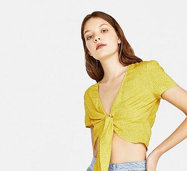 Camiseta con nudo delantero en color mostaza, 3,99 euros.