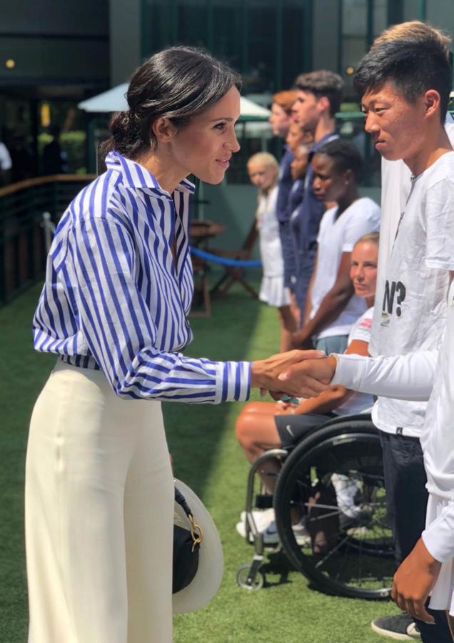 Desenfadado y cómodo. Un  look perfecto  para un partido de Wimbledon. Meghan acudió al torneo con una camisa de rayas y un pantalón palazzo de Ralph Lauren.