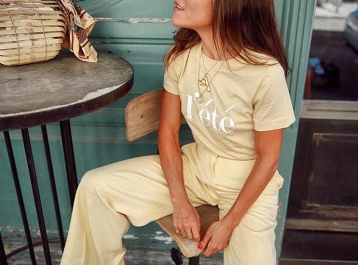 Pantalón de pinzas y camiseta con mensaje. El detalle está en el bolso, de varas de madera con un pañuelo atado.