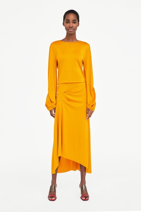 Midi, en amarillo ( el color del verano ) y con un favorecedor drapeado en la cadera. El precio de esta falda en las últimas rebajas de Zara pasa de 19.95 a 7.99 euros.