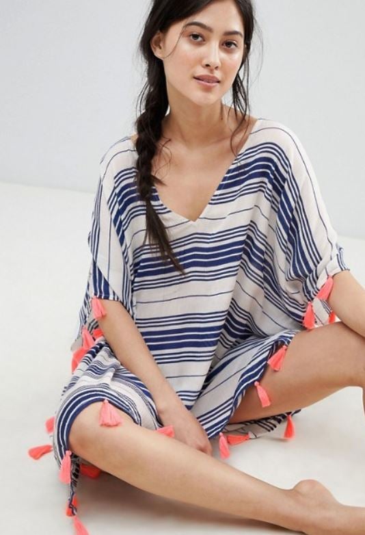 Caftán estilo poncho, a rayas y borlas rosas (30,99 euros).