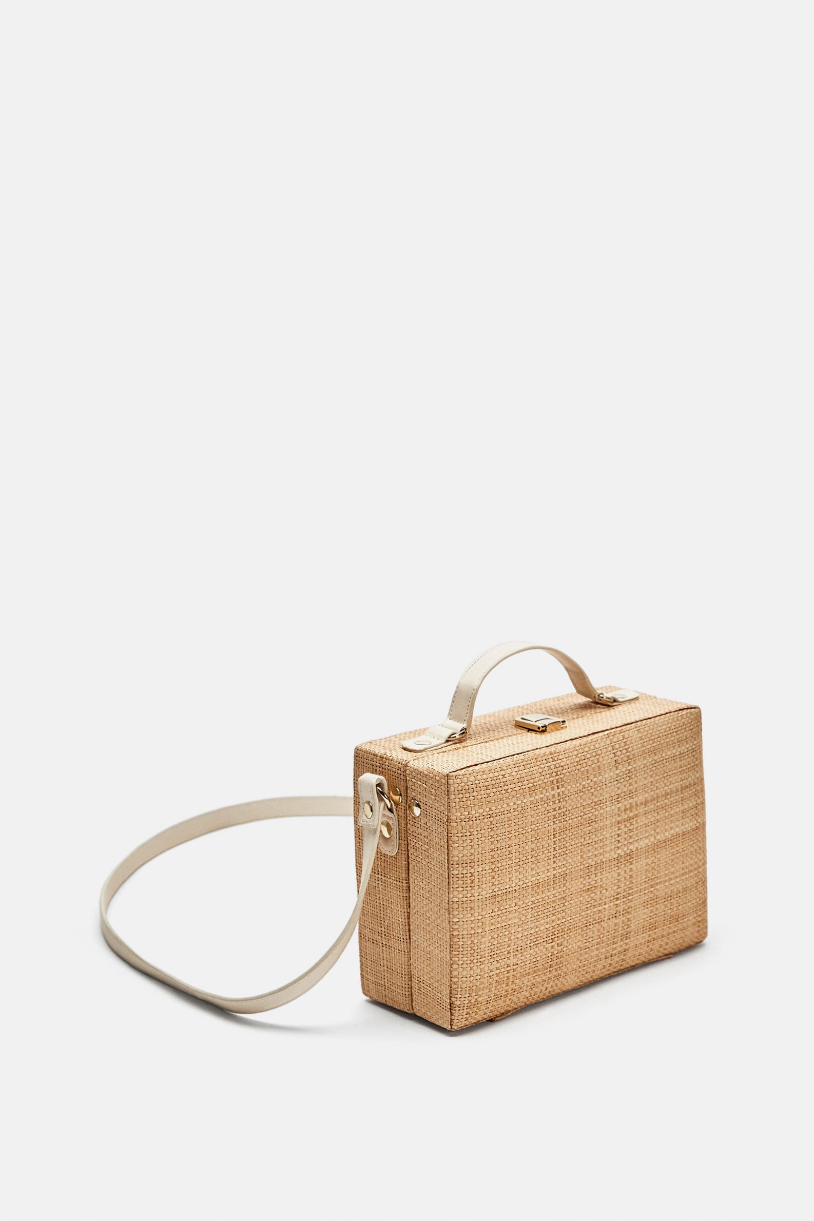 Caja de rafia color natural. También con forma de minimaletín y asas en piel, de Zara (35,95 euros).