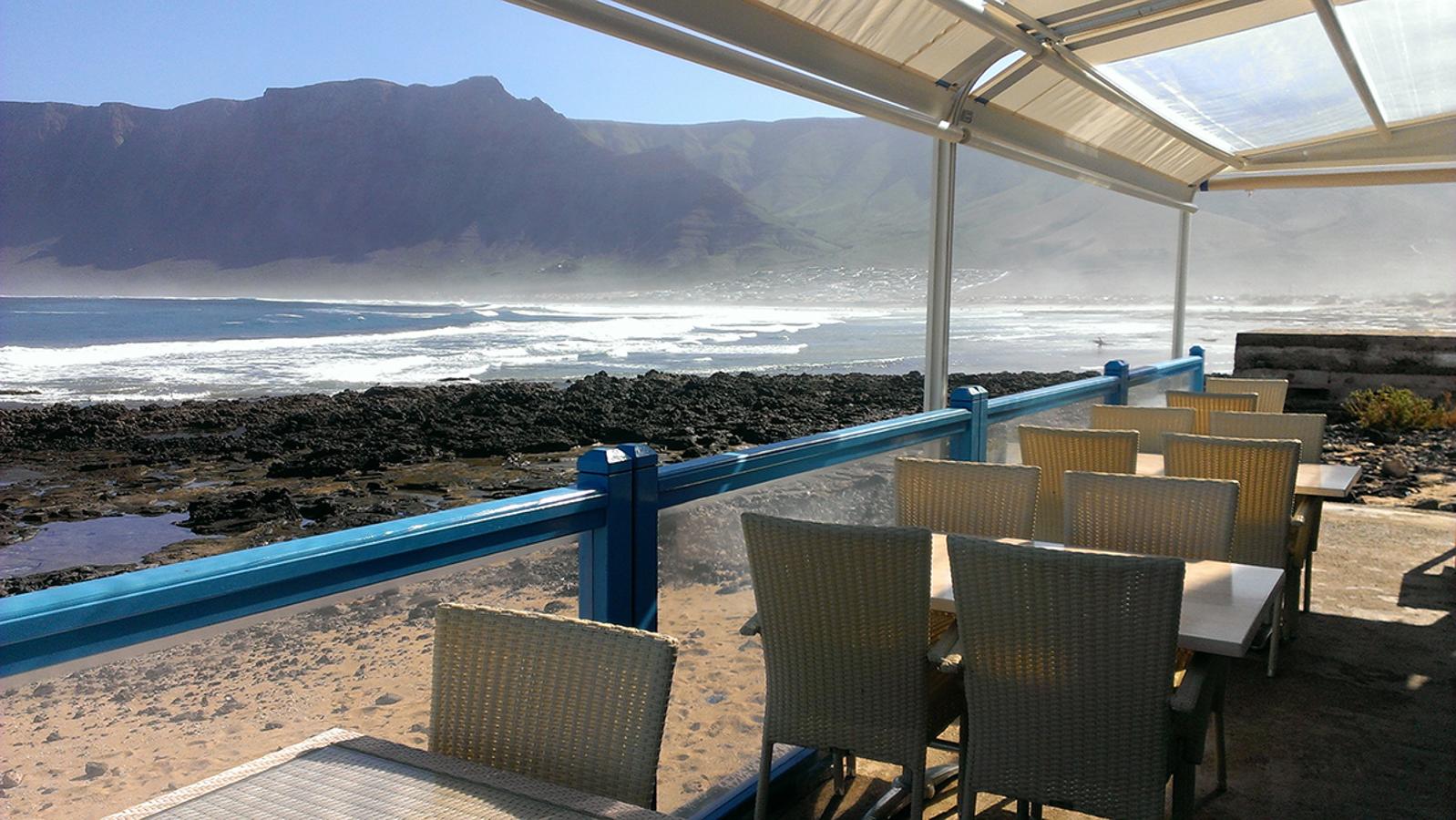 Dentro de una Reserva Marina y a la vez Parque Natural, el restaurante El Risco de Lanzarote nos permite disfrutar de su cocina marinera con la imponente vista de la playa de Famara a nuestros pies.