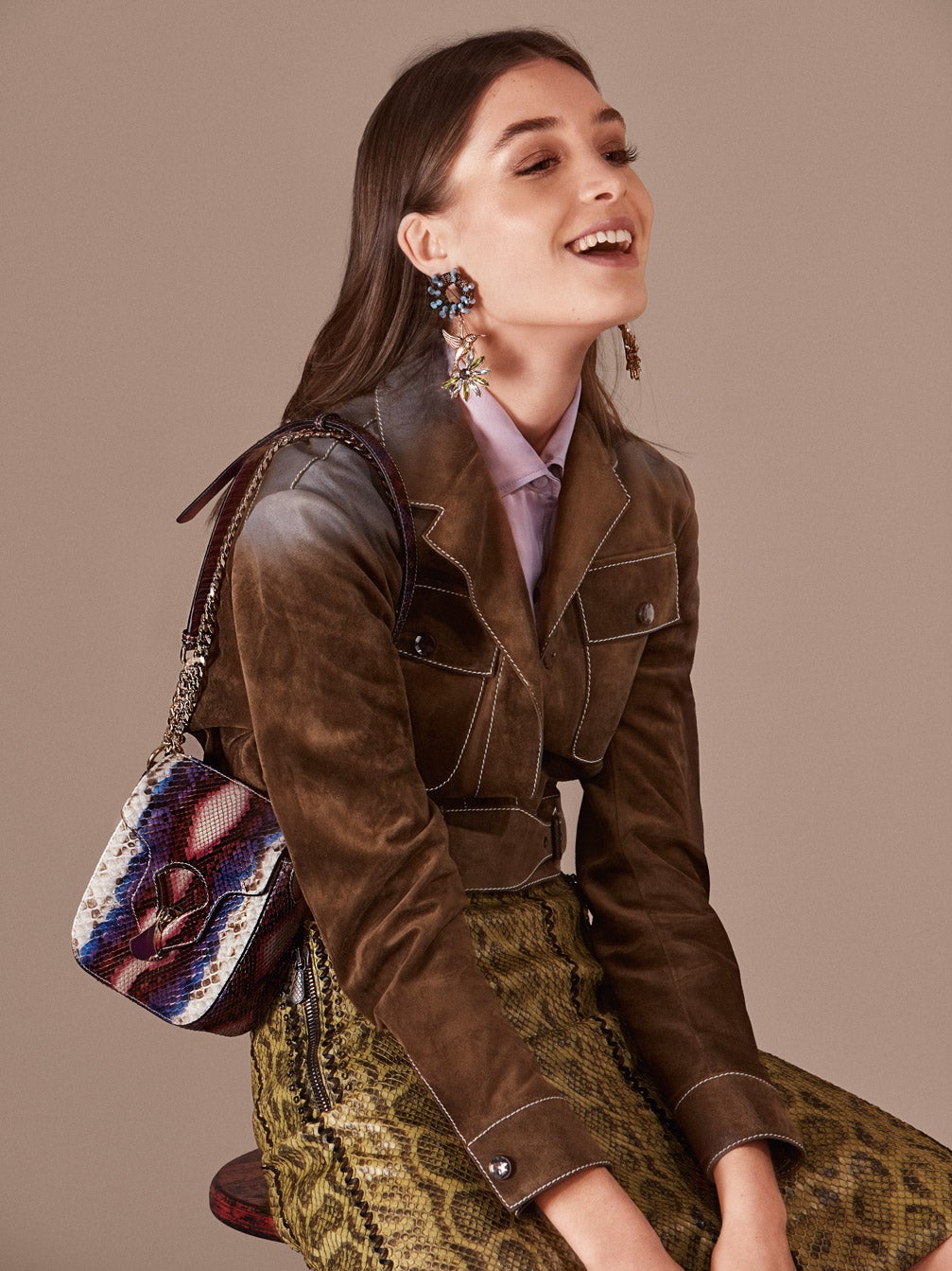 De Bottega Veneta son la cazadora de ante, la camisa de seda y falda de piel de serpiente. El bolso y el anillo son de Bulgari y los pendientes, de Uterqüe.